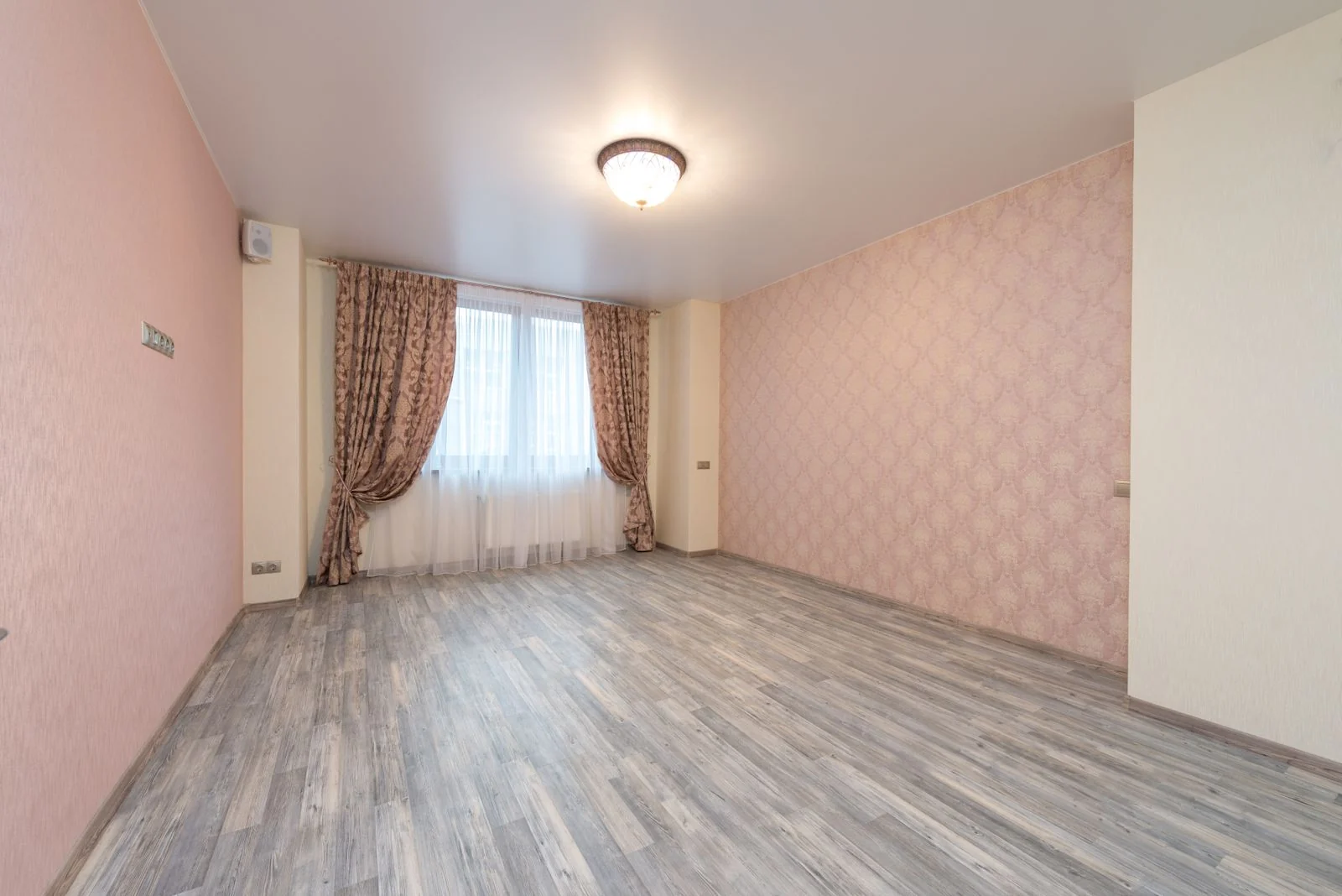 Empty room with a light gray washed plank floor